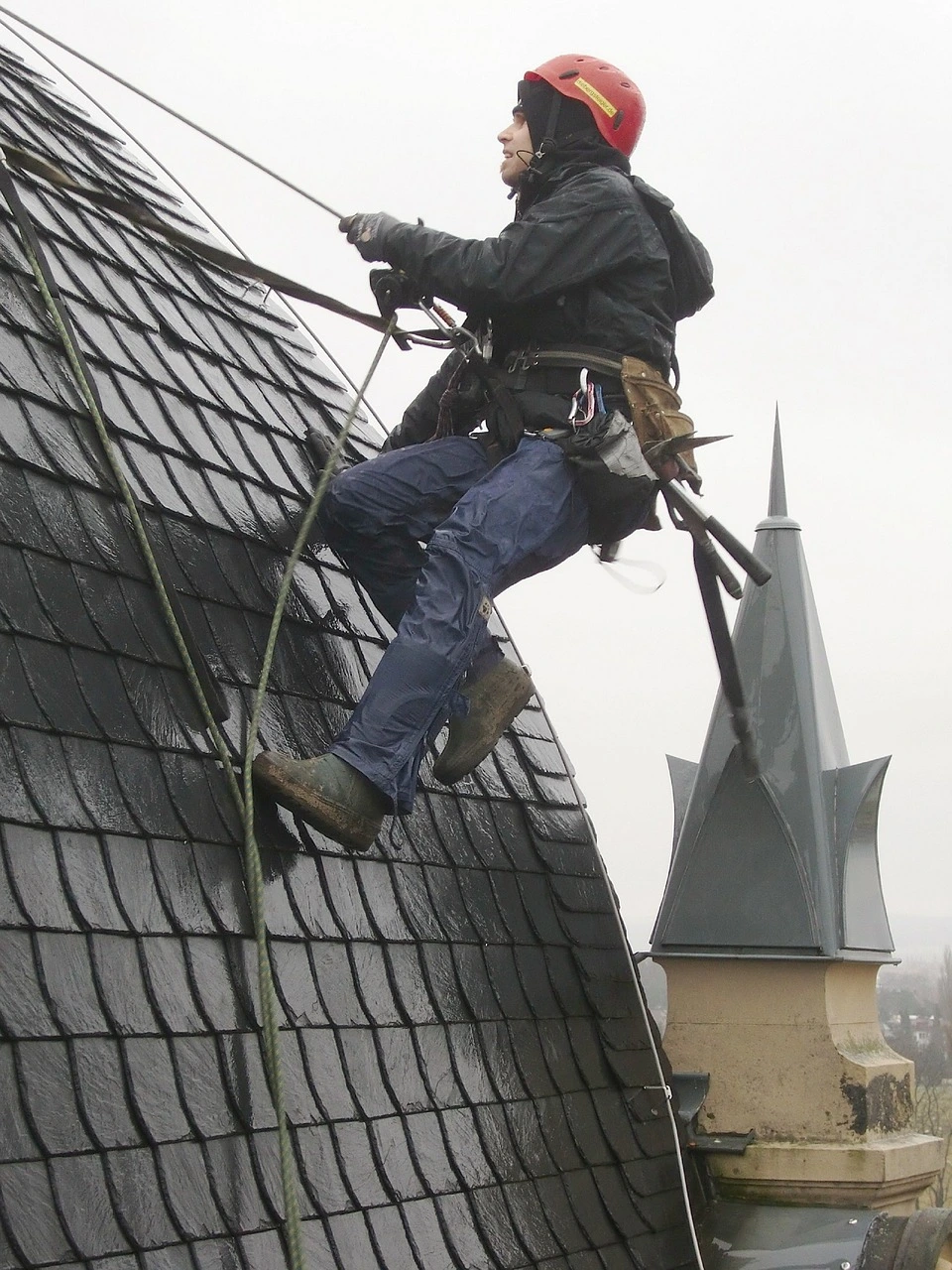 A roof cleaner hanging on a roof