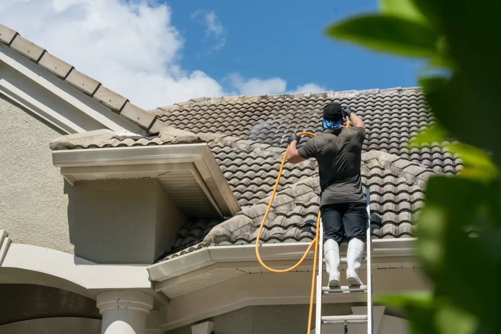 A man pressure washing a roof in Portland, Oregon