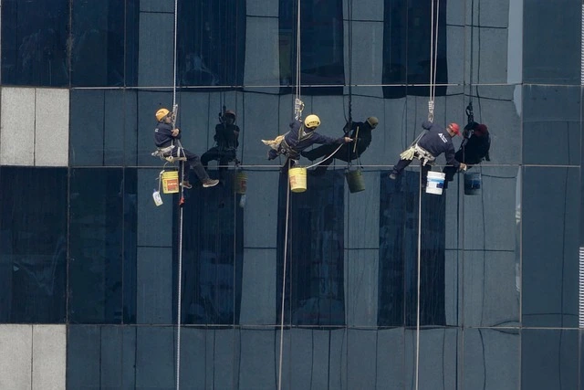 Residential roof cleaners hanging from a building