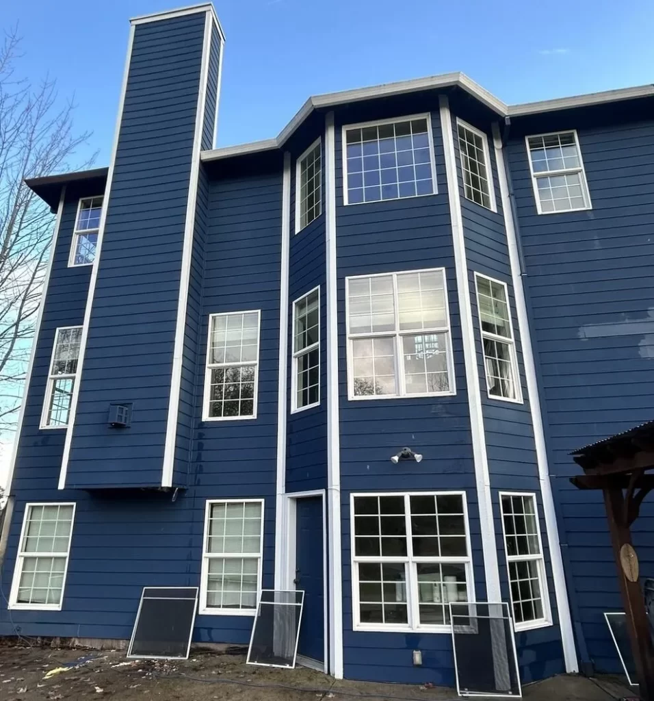 a blue house with high windows before window cleaning service