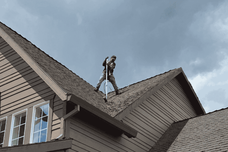 man brushing moss from roof