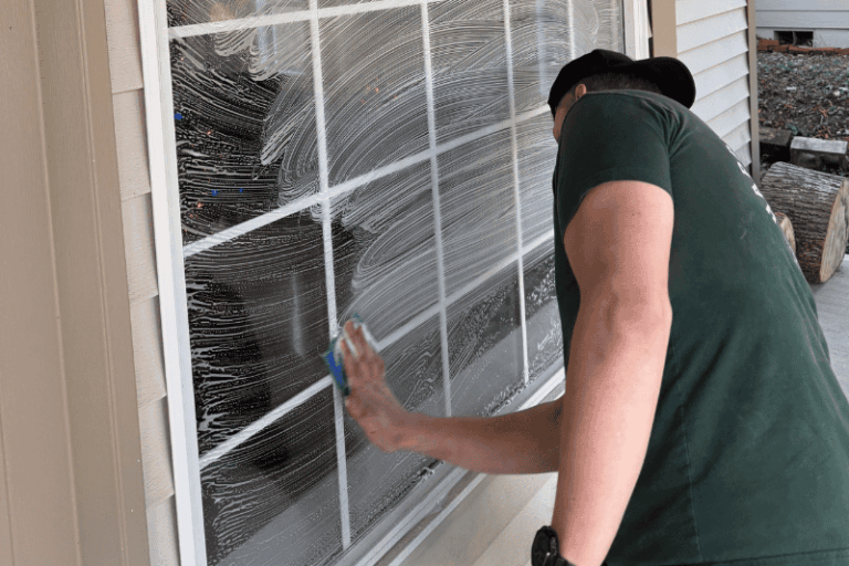 man scrubbing a window during cleaning