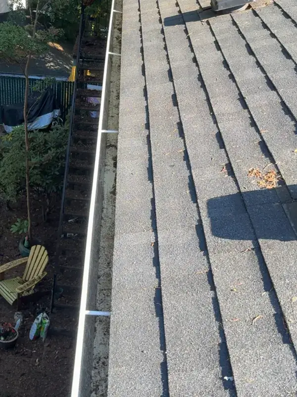 The same Portland roof edge after cleaning, with the shingles clear and the gutter emptied